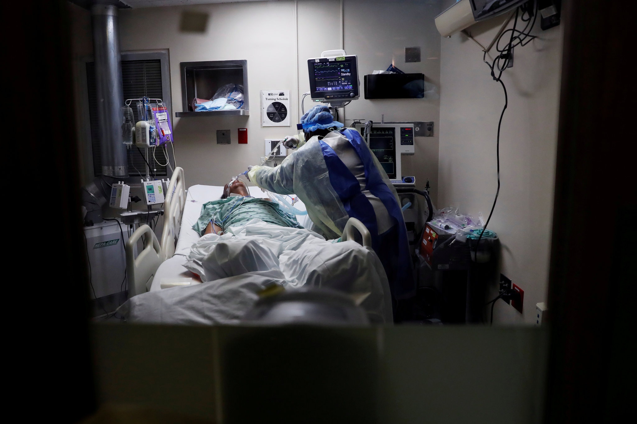 Медсестра ввела глубокую всасывающую трубку в легкие больного коронавирусом в отделении реанимации в Чикаго